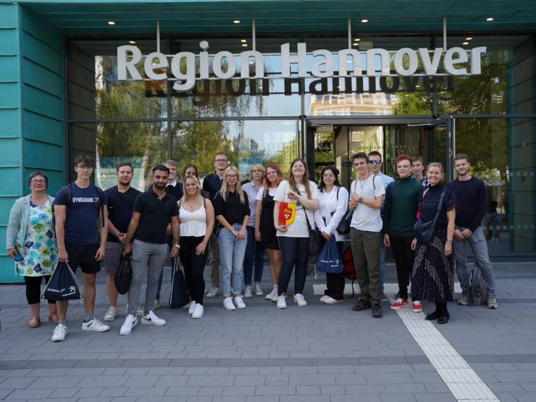 Eine Gruppe junger Menschen steht vor einem Gebäude "Region Hannover"